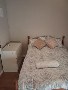 a bedroom with a bed with a pillow and a night stand at 2 bedroom house 