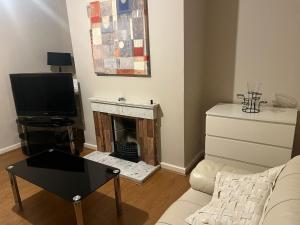 a living room with a fireplace and a tv at 2 bedroom house 