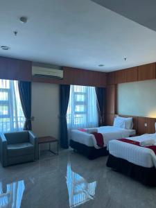 a hotel room with two beds and a chair at Utc Damhil By Prasanthi in Telaga