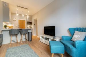 a living room with a blue couch and a kitchen at 1 Bed in Grasmere oc-lr068 in Grasmere +9 photos