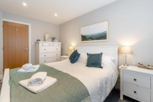 a bedroom with a large white bed and a dresser at 1 Bed in Grasmere oc-lr068 in Grasmere