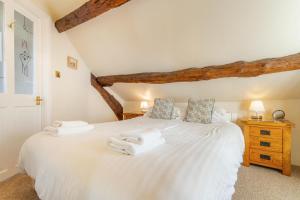 a bedroom with a white bed with towels on it at 1 Bed in Hawkshead oc-lr072 in Hawkshead