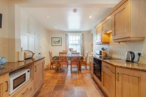 a kitchen with wooden cabinets and a dining room at 4 Bed in Ambleside oc-lr082 in Ambleside
