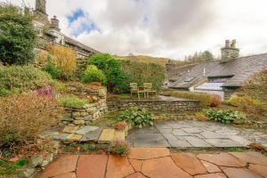 a garden with a patio and a table and chairs at 4 Bed in Ambleside oc-lr082 in Ambleside