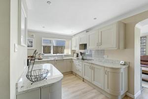 a kitchen with white cabinets and marble counter tops at 4 Bed in Ambleside oc-lr120 in Ambleside