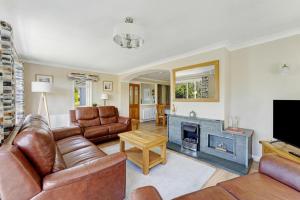a living room with leather furniture and a fireplace at 4 Bed in Ambleside oc-lr120 in Ambleside