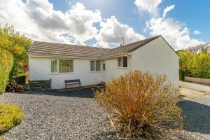 a white house with a bench in a driveway at 4 Bed in Ambleside oc-lr120 in Ambleside