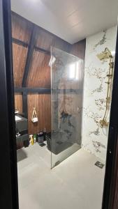 eine Glasdusche in einem Raum mit einer Wand in der Unterkunft Dar Batroun in Batrun