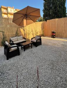 eine Terrasse mit zwei Sofas und einem Tisch mit Sonnenschirm in der Unterkunft Dar Batroun in Batrun