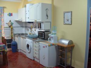 a kitchen with white cabinets and a washing machine at Villa Vau in Portimão
