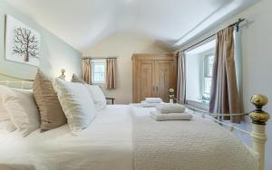 a bedroom with a large white bed with white pillows at 1 Bed in Grasmere oc-lr124 in Grasmere