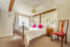 a bedroom with a bed with pink pillows and a chair at 5 Bed in Hawkshead oc-lr134 in Hawkshead