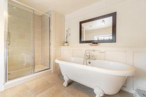 a white bathroom with a tub and a shower at 5 Bed in Hawkshead oc-lr134 in Hawkshead +21 photos
