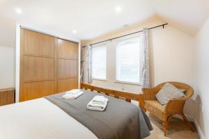 a bedroom with a bed and a chair and a window at 1 Bed in Skelwith Bridge oc-lr159 in Elterwater