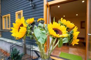 a vase filled with yellow sunflowers in front of a house at 1 Bed in Skelwith Bridge oc-lr159 in Elterwater