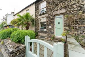 a stone house with a green door and a white fence at 3 Bed in Windermere oc-lr164 in Windermere