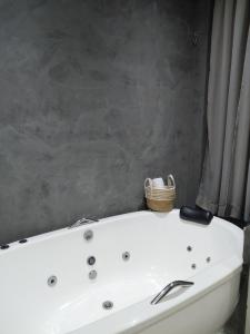 a white bath tub with a basket on top of it at Chalé Jaguary com hidro,Monte Verde MG in Companhia