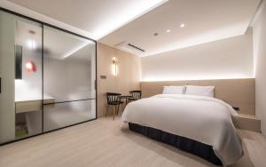 a bedroom with a bed and a table and chairs at H hotel Gasan in Seoul