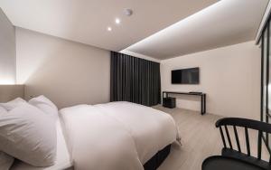 a bedroom with a white bed and a television at H hotel Gasan in Seoul +23 photos
