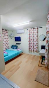 a room with a bed and a desk and curtains at Pak Long Man Roomstay in Pendang