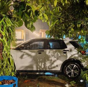 a white car is parked under a tree at Pak Long Man Roomstay in Pendang