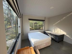a small bedroom with two beds and a window at Refúgio Deusmideu in São Bento do Sapucaí +58 photos