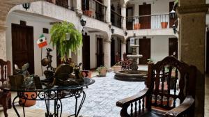 a courtyard with a table and chairs in a building at Hotel Don Quijote Plaza - Guadalajara Centro Historico in Guadalajara