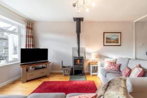 a living room with a couch and a wood stove at 2 Bed in Ambleside oc-lr114 in Chapel Stile