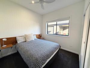 a bedroom with a bed and a window at Loveday on Landsborough in South West Rocks