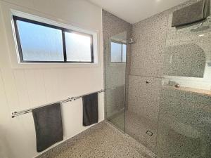 a bathroom with a shower and a sink and a window at Loveday on Landsborough in South West Rocks +14 photos