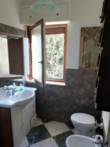 a bathroom with a toilet and a sink and a window at Greenhouse Torino in Turin +4 photos