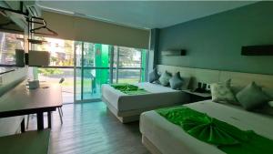 una camera da letto con due letti, un tavolo e una scrivania di HOTEL LEMON GREEN -Zona Expo Frente al Centro de Convenciones a Guadalajara Altre 91 foto