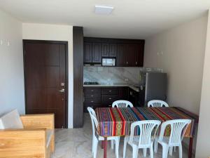 a kitchen with a table and chairs and a kitchen with a refrigerator at Volcán Suits in Baños