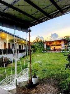 a couple of white chairs sitting in a yard at Veronica Palms in Pooc