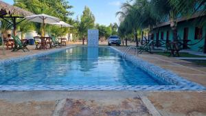 a swimming pool with a fountain in a resort at Pousada Brisa do Mar in Barrinha +12 photos