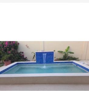 a swimming pool with a fountain in the middle at La Villas at Pos Chiquito Caribbean Paradise in Aruba in Savaneta