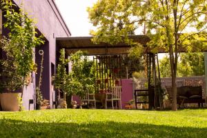 a purple building with a tree in a yard at Refugio Padma in Chacras de Coria