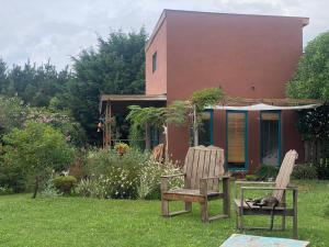 a cat sleeping on a chair in front of a house at Tiny House Marencalma in Santa Clara del Mar