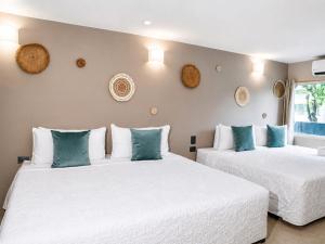 two beds in a room with white and blue pillows at Hotel Bocagrande Cartagena in Cartagena de Indias +115 photos