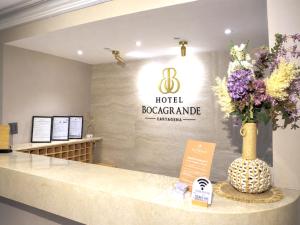 a hotel reception counter with a vase of flowers at Hotel Bocagrande Cartagena in Cartagena de Indias