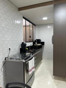 a kitchen with a stove and a counter top at Apartamento completo 2 quartos in Brasília +2 photos
