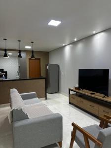 a living room with a couch and a flat screen tv at Apartamento completo 2 quartos in Brasília
