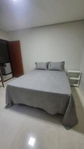 a bedroom with a bed and a flat screen tv at Apartamento completo 2 quartos in Brasília