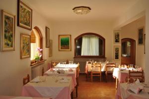 a dining room with tables with white tablecloths at Albergo Stella Alpina in San Pietro di Cadore