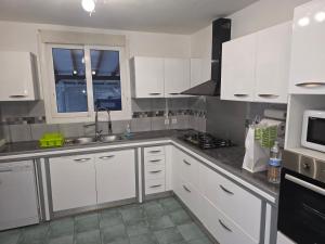 a kitchen with white cabinets and a sink and a window at Villa Ti'Sol in Saint-François +8 photos