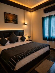 a bedroom with a large bed with blue curtains at RadhaRaman StayInn in Mathura +6 photos