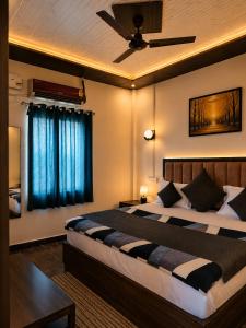 a bedroom with a large bed with a ceiling fan at RadhaRaman StayInn in Mathura