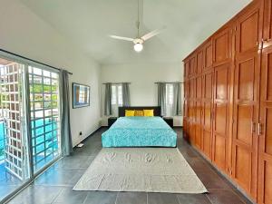 a bedroom with a bed and a large wooden closet at Villa Fidelina Picsina in Río San Juan +24 photos