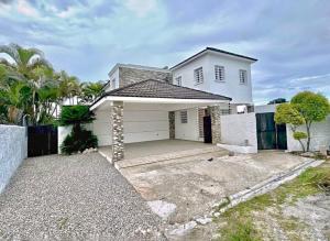 a white house with a driveway in front of it at Villa Fidelina Picsina in Río San Juan