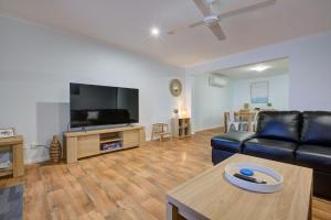 a living room with a couch and a flat screen tv at Billfish in Exmouth